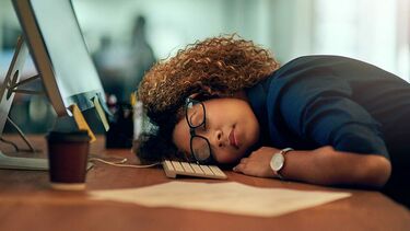 Woman asleep at work on a desk