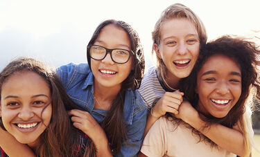 Four teenage girls smiling