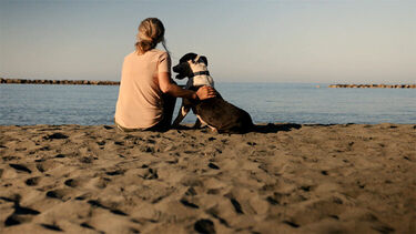 A woman with her dog on a beach