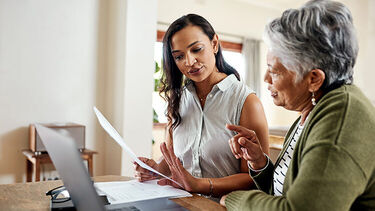 Two women talking around a laptop