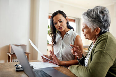 Two women talking around a laptop