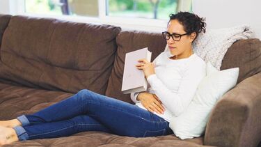 Woman sitting on couch with pelvic pain