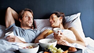 Couple having breakfast in bed