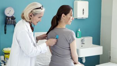 A doctor checking a patient's heartbeat