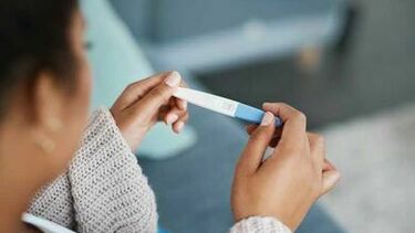 woman holding a pregnancy test