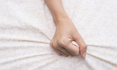Hand clenching bed sheet