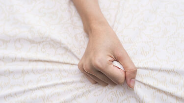 Hand clenching bed sheet